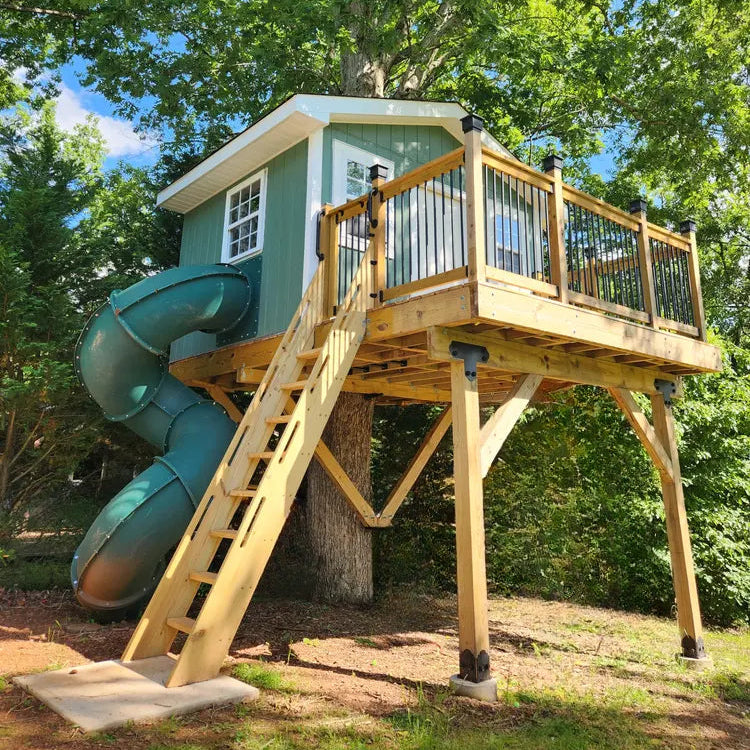 Treehouse with a slide and deck surrounded by trees